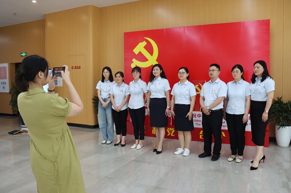 图为公共资源交易中心党支部党员在党旗下留影